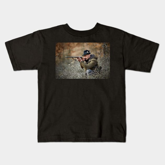 Hunter with gun in the forest Kids T-Shirt by naturalis